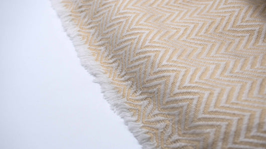 zoomed and close up view of Yellow And White Chevron Cashmere Blanket displaying the knitting details and micro fringes showing the quality of the yarn