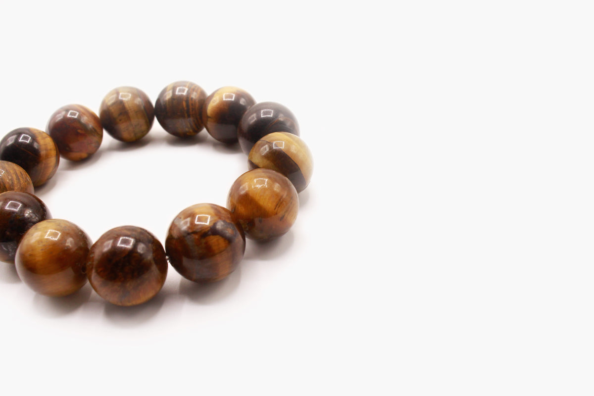 Close-up of polished 16 mm Tiger's Eye beads showing golden-brown banding.
