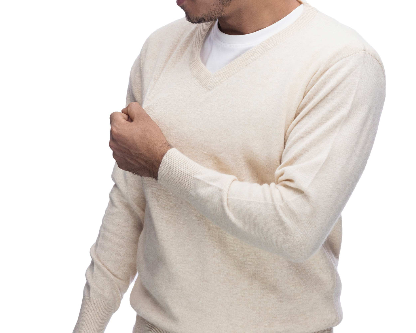 A man wearing a cream-colored v-neck knit sweater over a white undershirt, shown from the chest up against a plain white background.