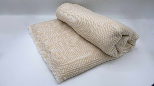 Yellow And White Chevron Cashmere Blanket which is half rolled and placed sideway for a more detailed view