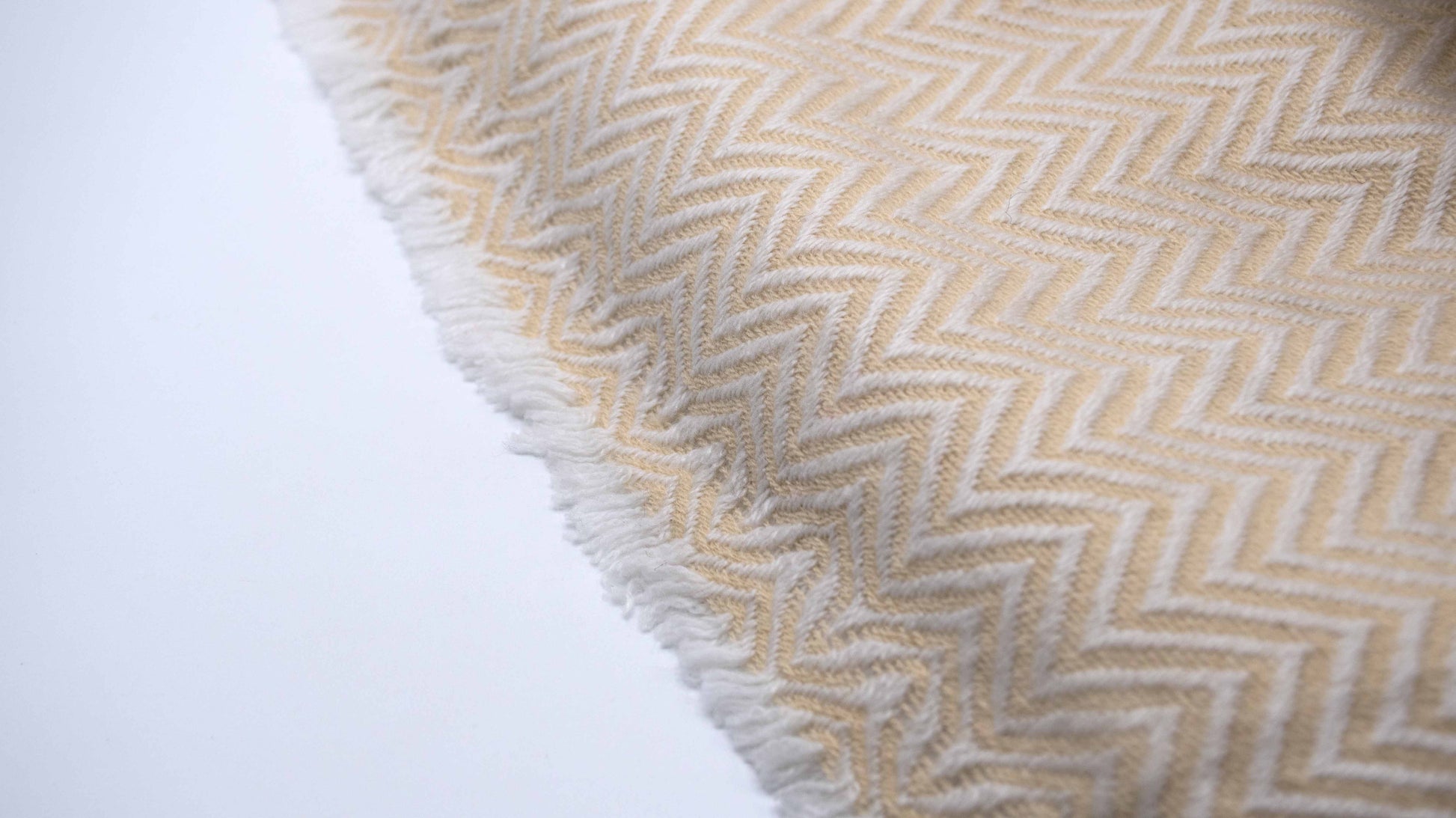zoomed and close up view of Yellow And White Chevron Cashmere Blanket displaying the knitting details and micro fringes showing the quality of the yarn