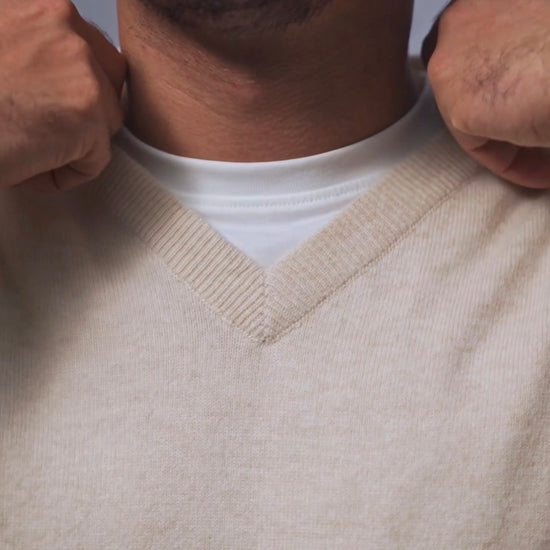 Men's v-neck knit sweater in cream and dark gray variants featuring ribbed neckline detail and classic fit.