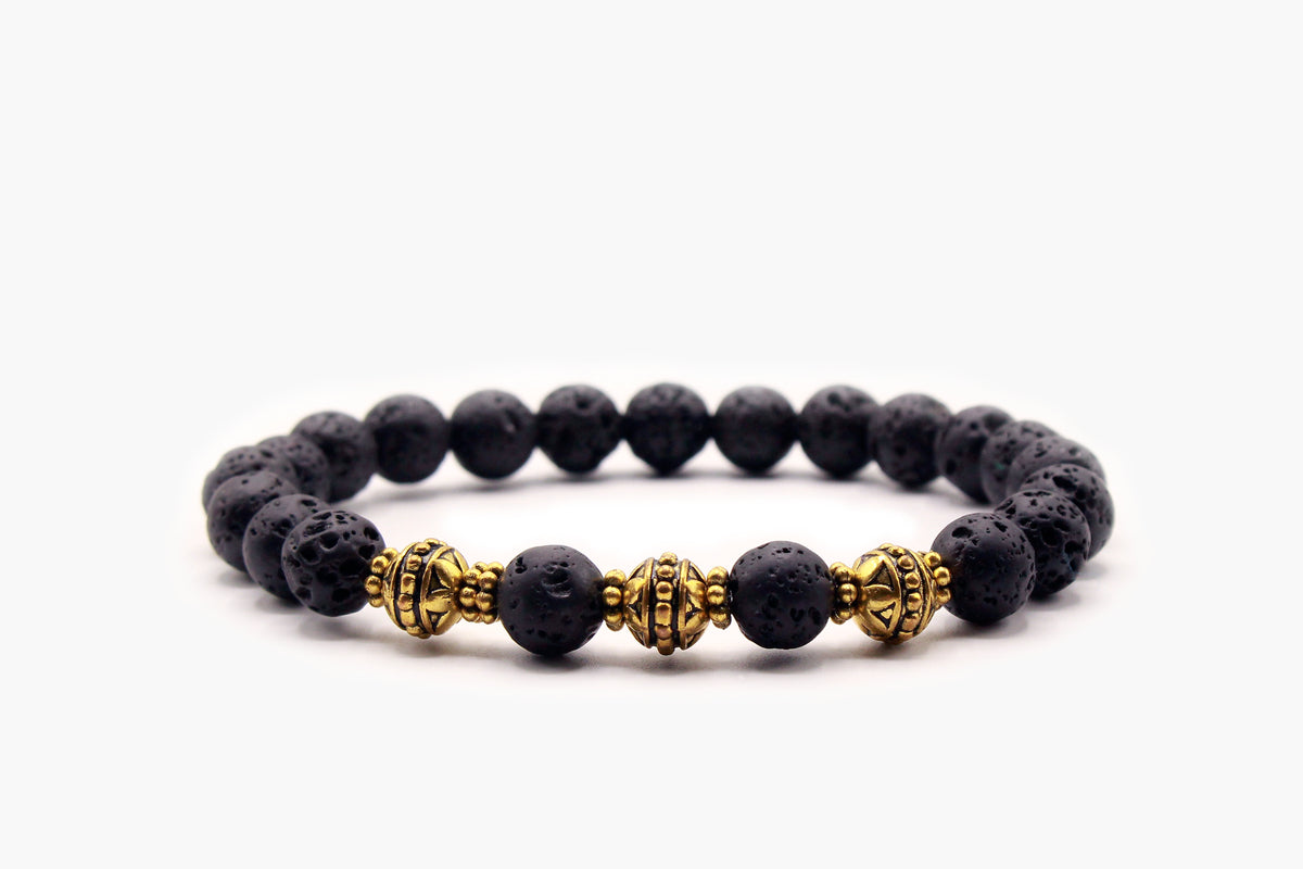 Black Lava Stone 8 mm bead bracelet with gold-tone decorative accents, front view.