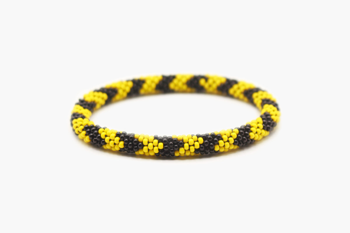 Black and yellow glass bead roll-on bracelet with repeating diagonal pattern.