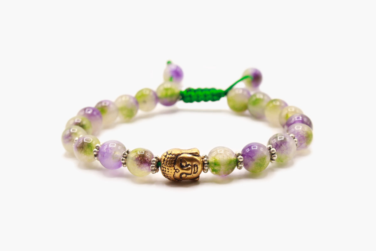 Green and purple Jade bead bracelet with a gold-tone Buddha face accent, front view.