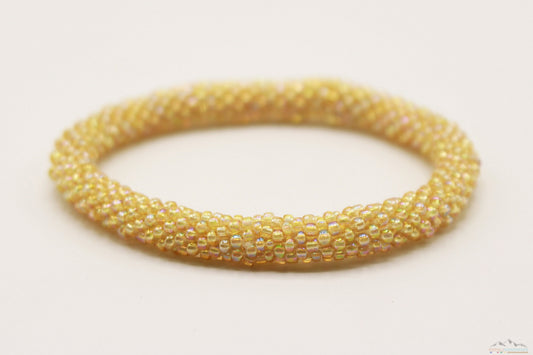 Iridescent golden yellow glass bead roll-on bracelet showing its reflective finish.