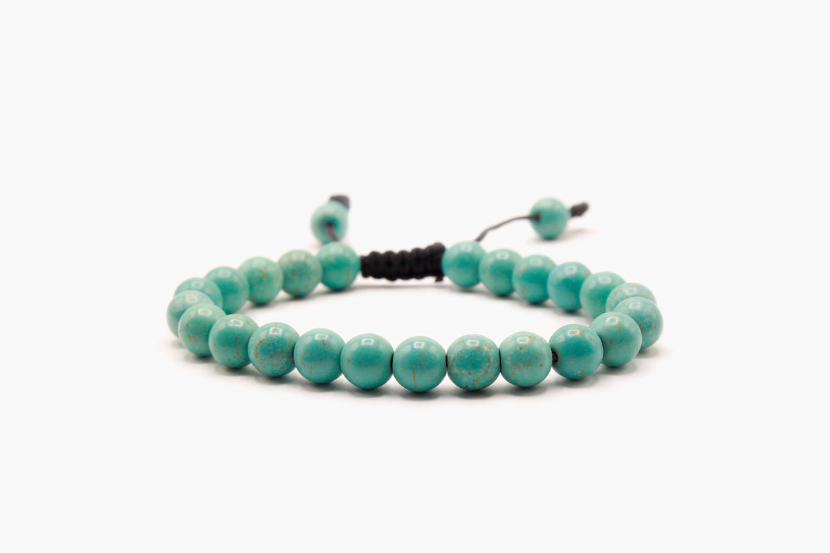 Light turquoise 8 mm bead bracelet with subtle tan-brown markings, front view.