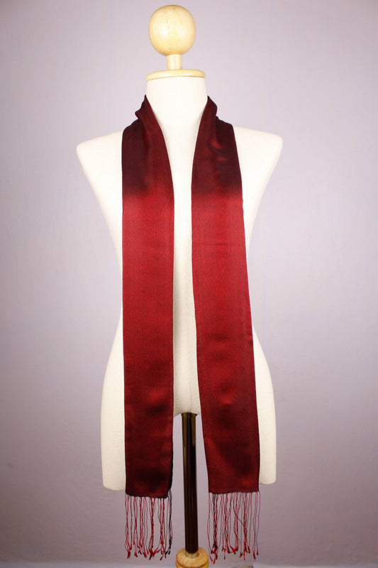 Women's 100% pure silk crimson red scarf fully draped on a mannequin, showing the scarf's full length and long braided fringes