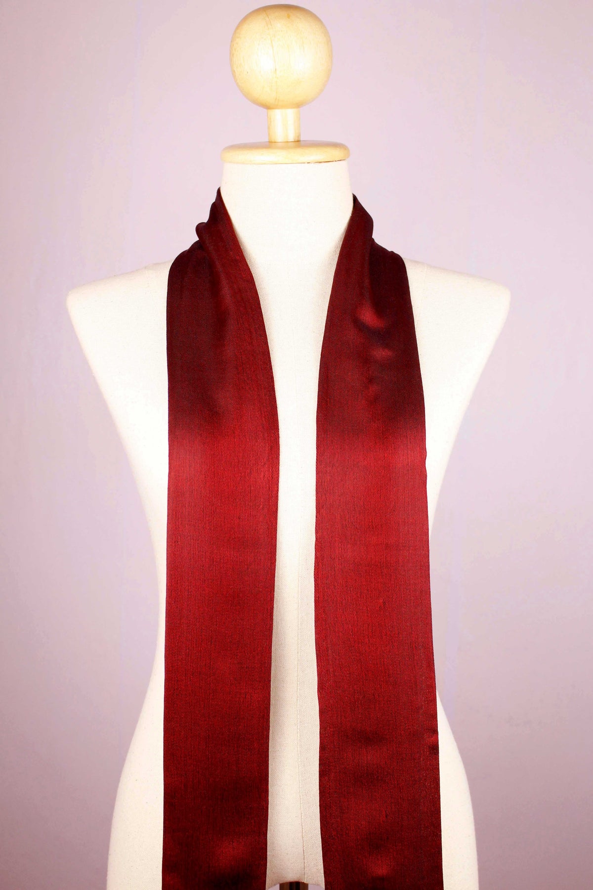 Women's 100% pure silk crimson red scarf fully draped on a mannequin, showing half mannequin view