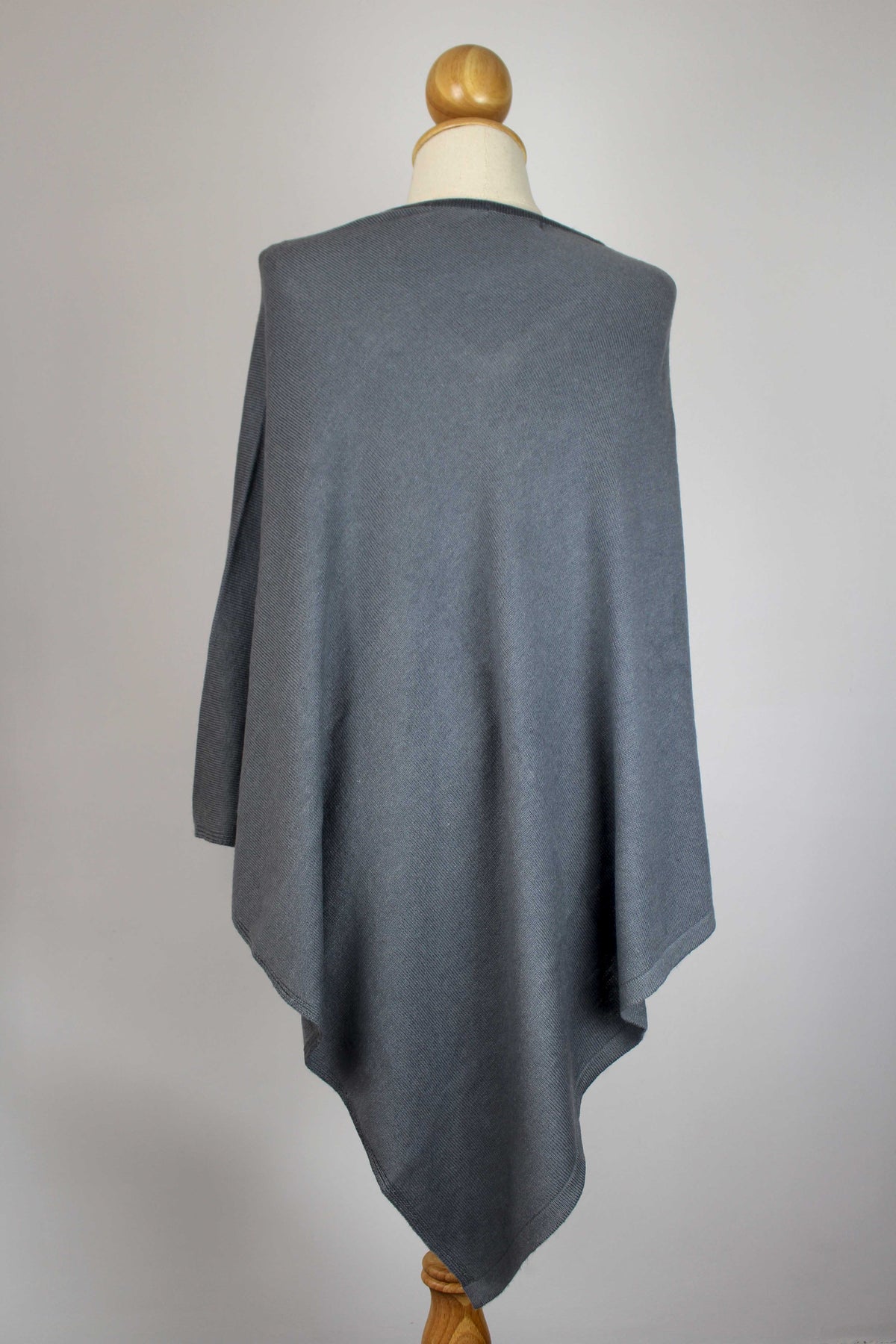 Women's slate gray cashmere poncho displayed on a mannequin, back view.