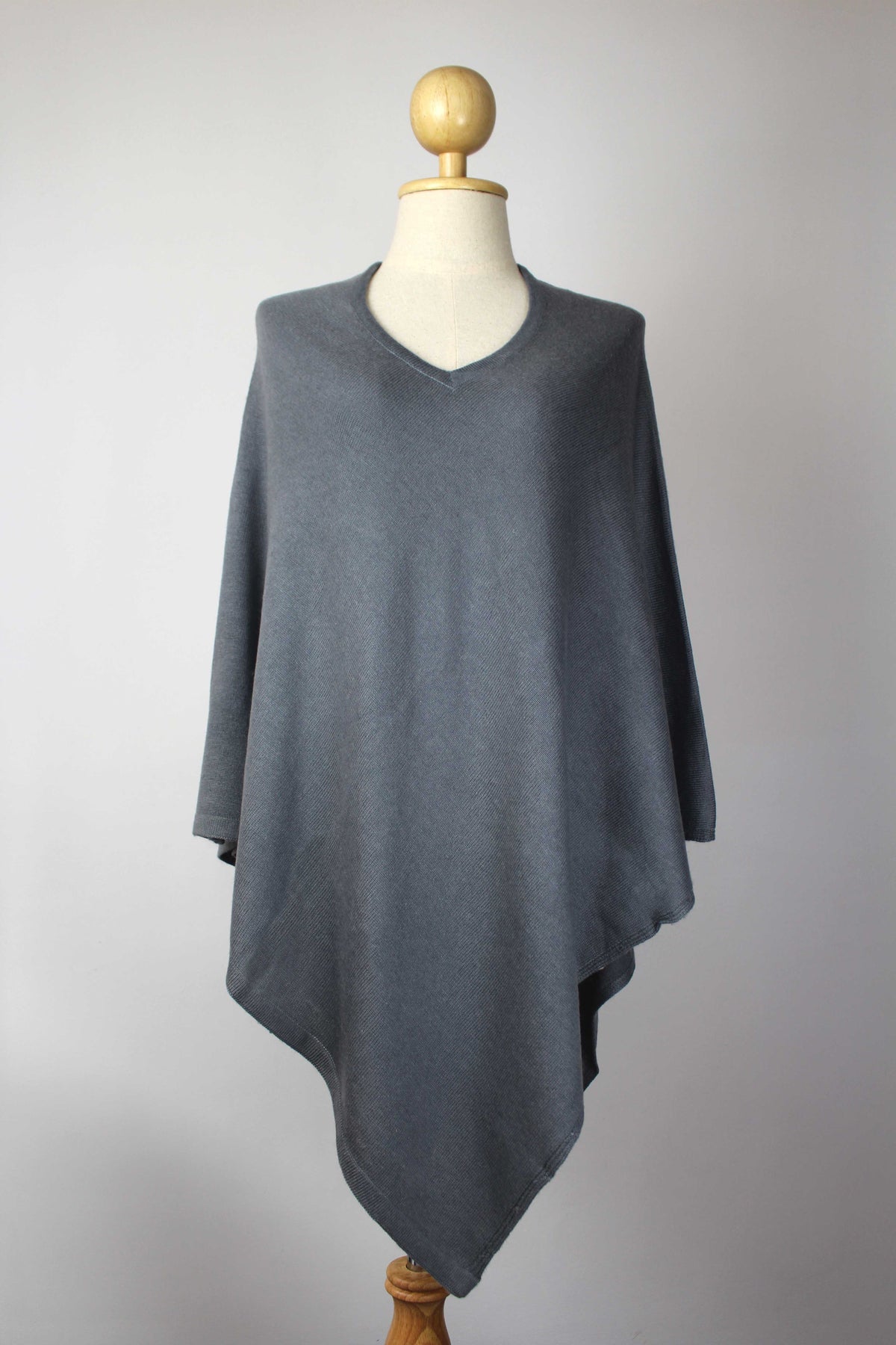 Women's slate gray cashmere V-neck poncho displayed on a mannequin, front view.