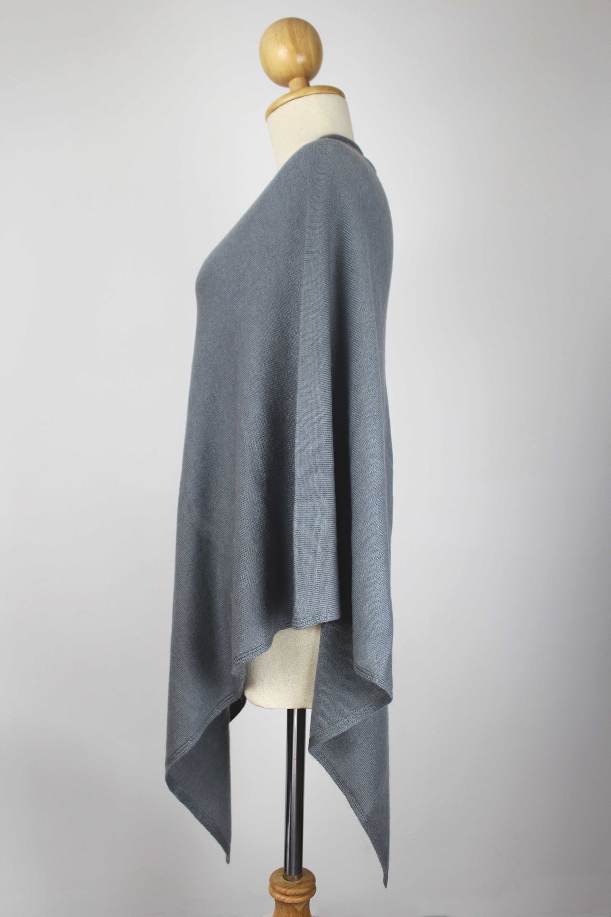 Women's slate gray cashmere poncho displayed on a mannequin, side view.