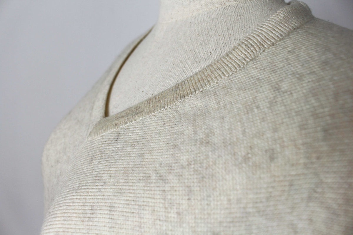 Close-up of the women's Cream cashmere poncho showing the V-neckline and fabric texture.