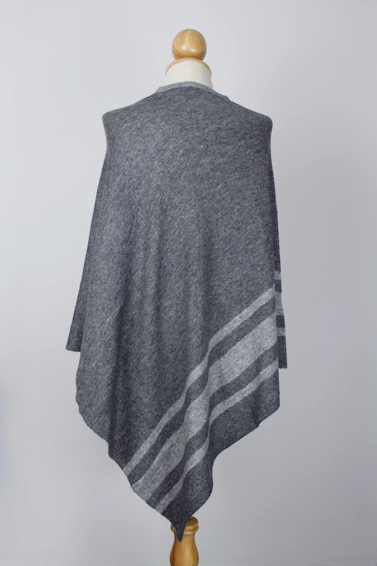 Women's dark gray cashmere poncho with Silver Gray stripe detailing, back view on a mannequin.
