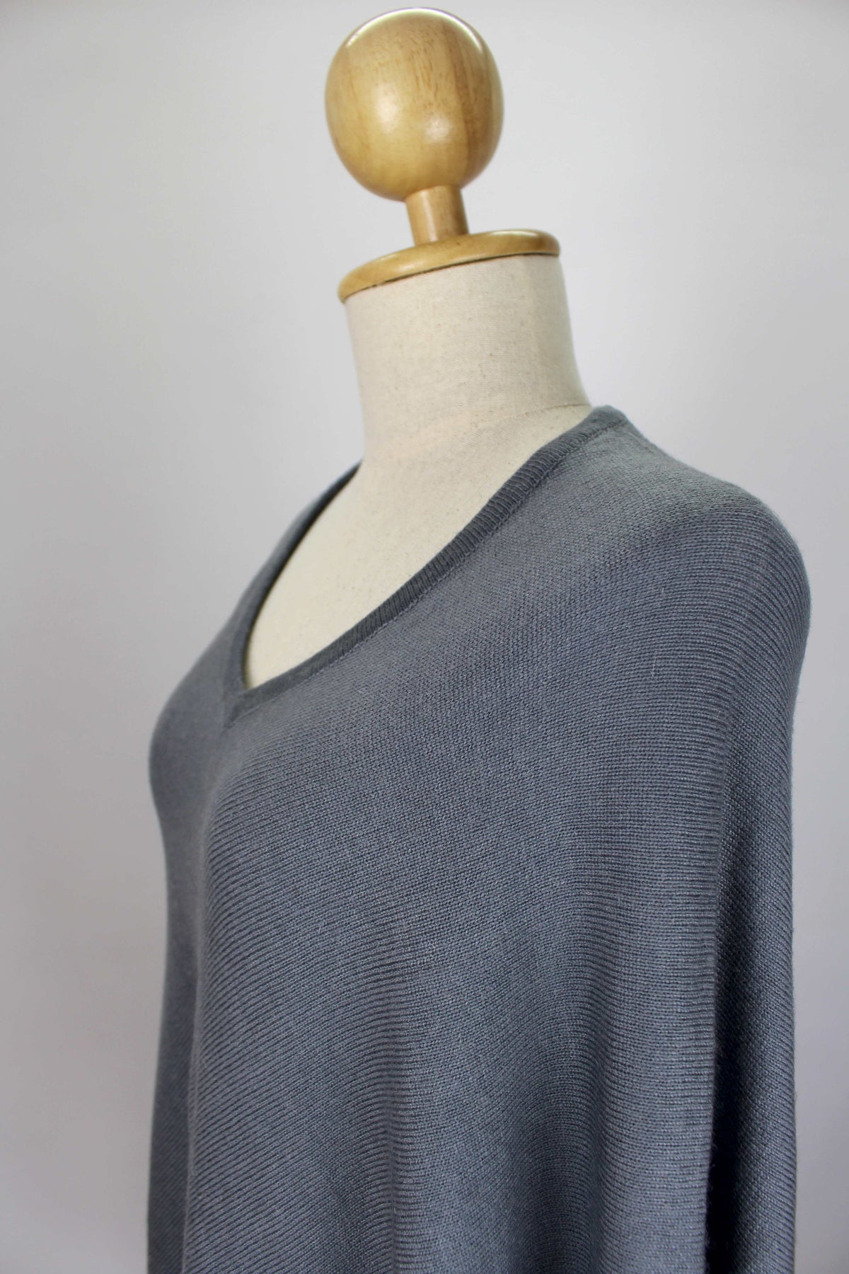 Close-up of the women's slate gray cashmere poncho showing the V-neckline and fabric texture.