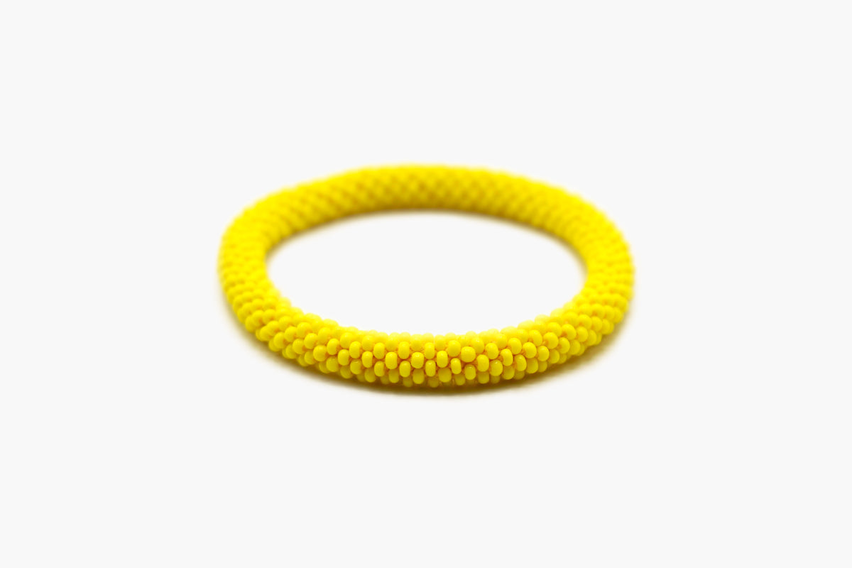 Bright yellow glass bead roll-on bracelet, front view.