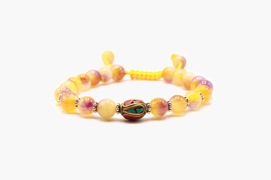 Yellow Jade bead bracelet with a central multicolor Tibetan bead, front view.