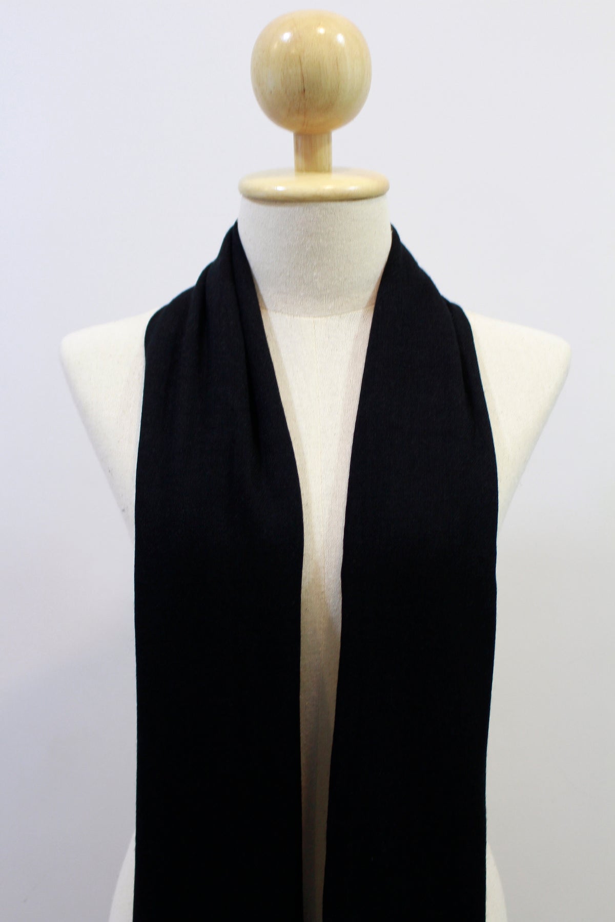 Classic Black cashmere scarf draped on a mannequin, front view.