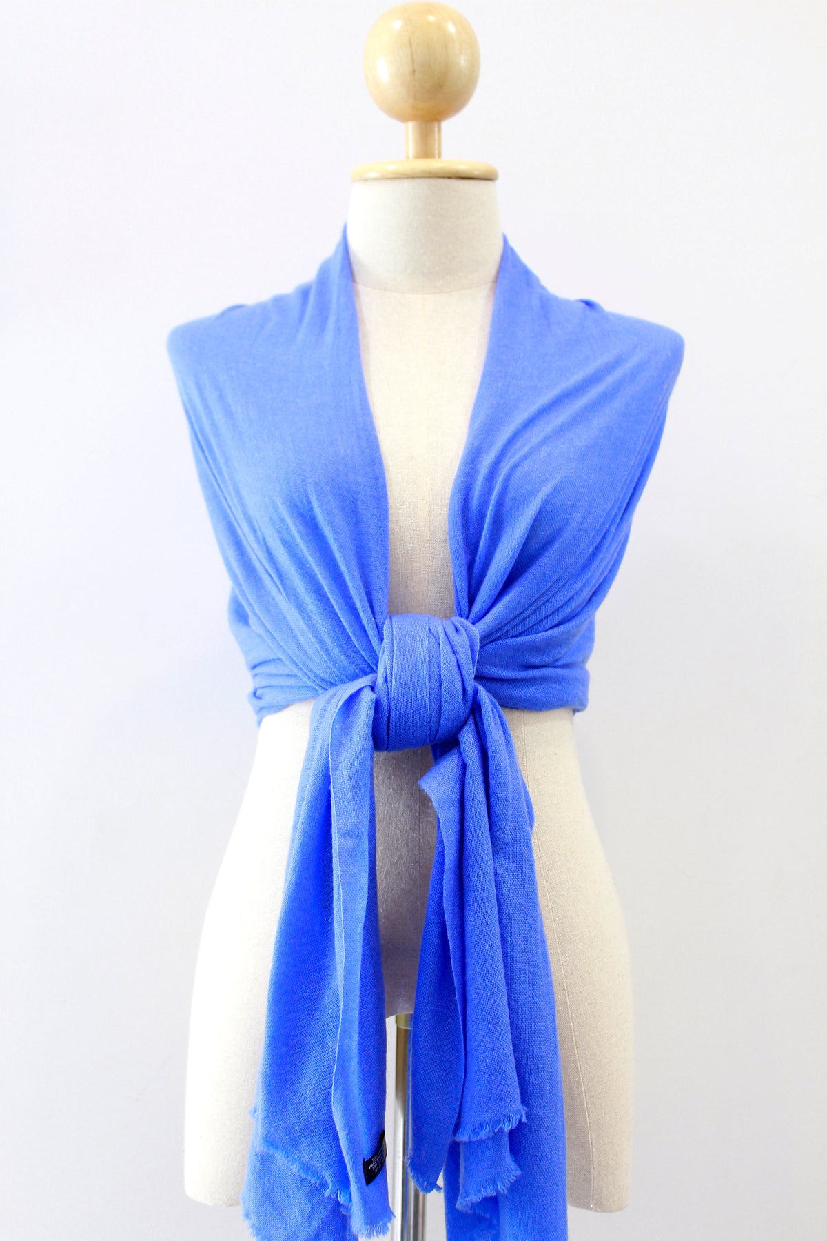 Cornflower Blue cashmere scarf draped over the shoulders on a mannequin.