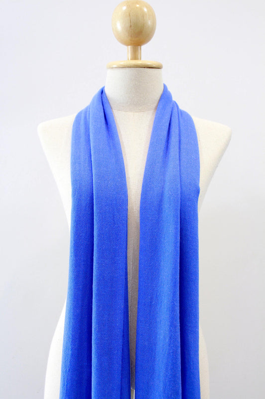 Cornflower Blue cashmere scarf draped around the neck of a mannequin, front view. 