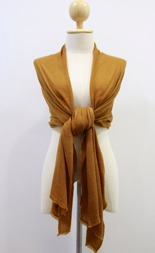 Mustard Yellow cashmere scarf draped over the shoulders and styled with a front knot on a display mannequin 