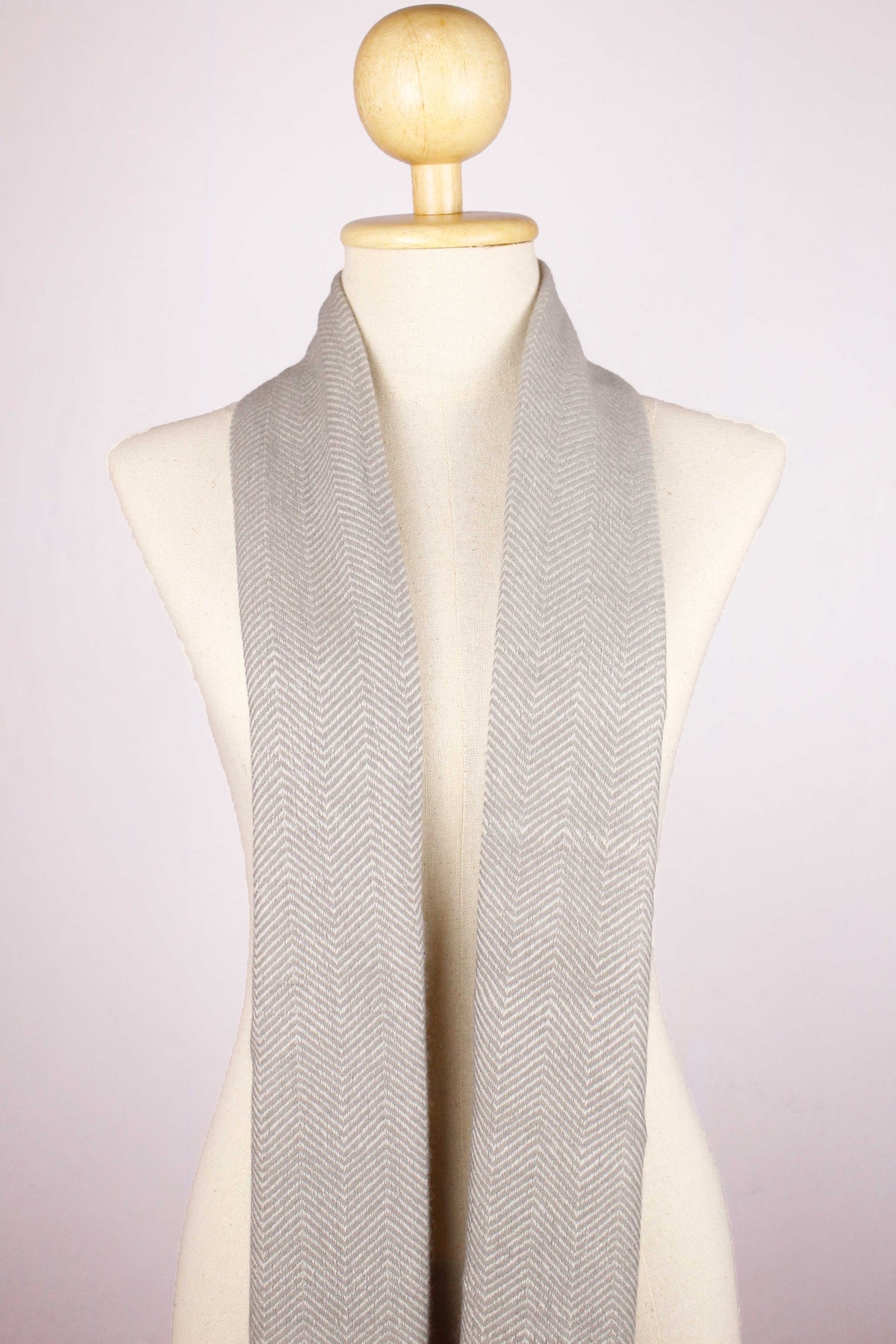 Women's cashmere wool chevron warm gray scarf draped around the neck, front view